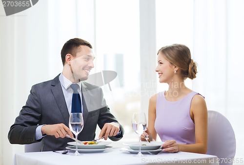 Image of smiling couple eating appetizers at restaurant