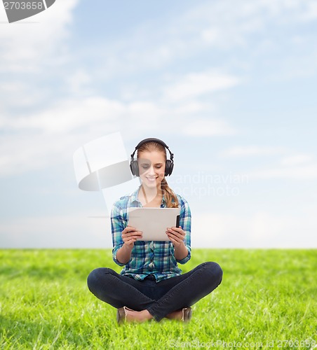 Image of young woman in casual clothes sitting on floor