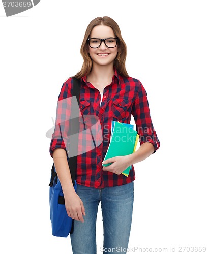 Image of smiling female student with bag and notebooks