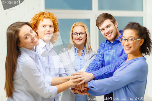 Image of team with hands on top of each other in office