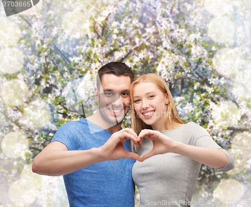 Image of smiling couple showing heart with hands