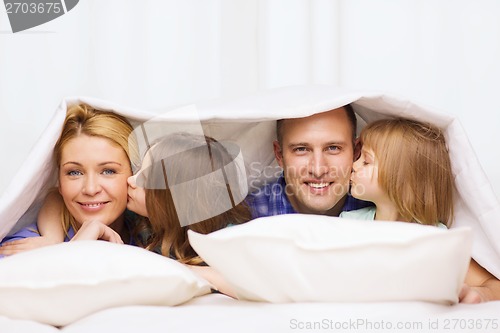 Image of two little girls kissing their parents on cheek