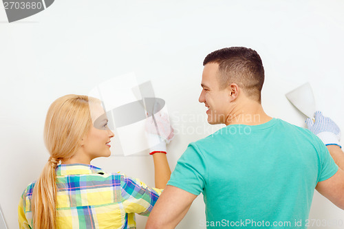 Image of smiling couple doing renovations at home