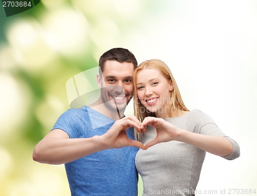 Image of smiling couple showing heart with hands