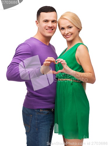 Image of smiling couple showing heart with hands