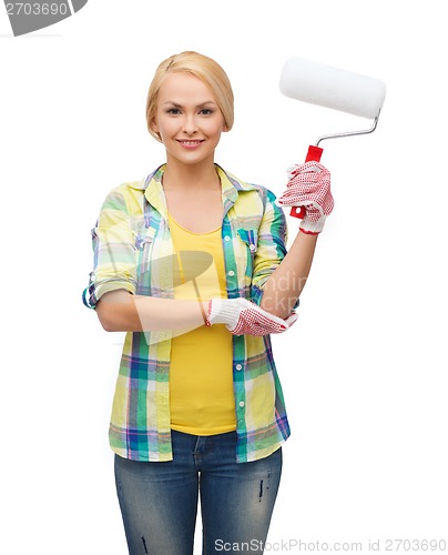 Image of smiling woman in gloves with paint roller