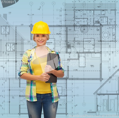 Image of smiling woman in helmet with clipboard