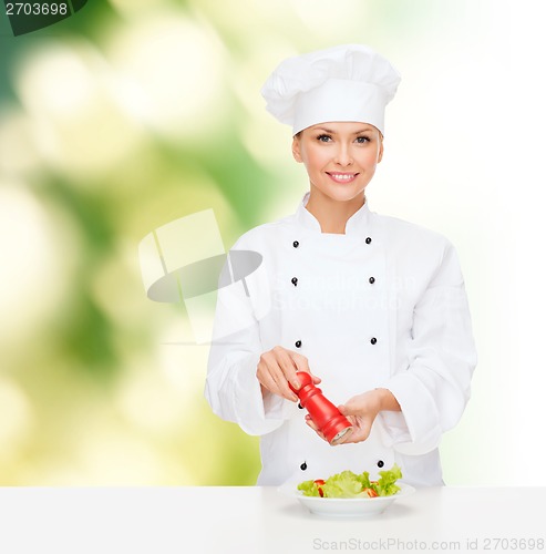 Image of smiling female chef with preparing salad