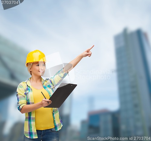 Image of smiling woman in helmet with clipboard