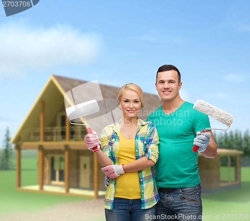 Image of smiling couple in gloves with paint rollers