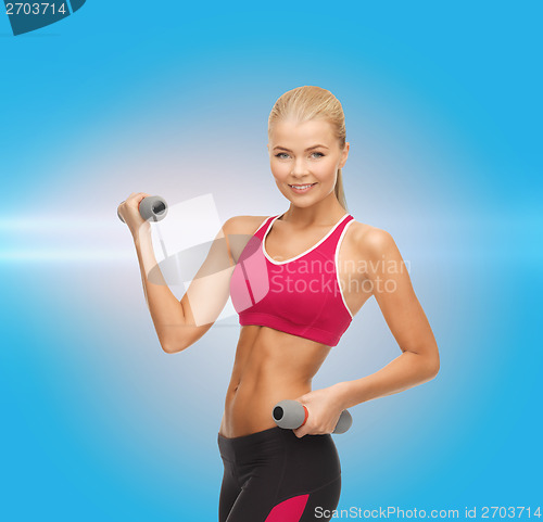 Image of young sporty woman with light dumbbells