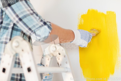 Image of close up of male in gloves holding paintbrush