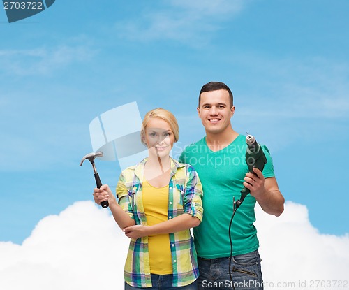 Image of smiling couple with hammer and drill