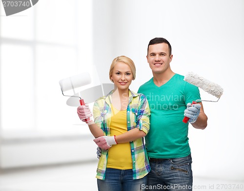 Image of smiling couple in gloves with paint rollers