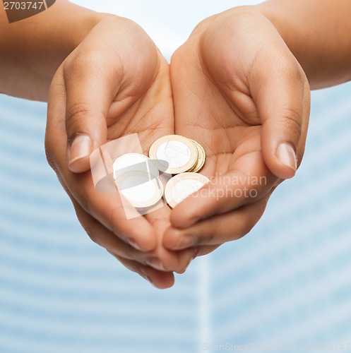 Image of womans cupped hands showing euro coins