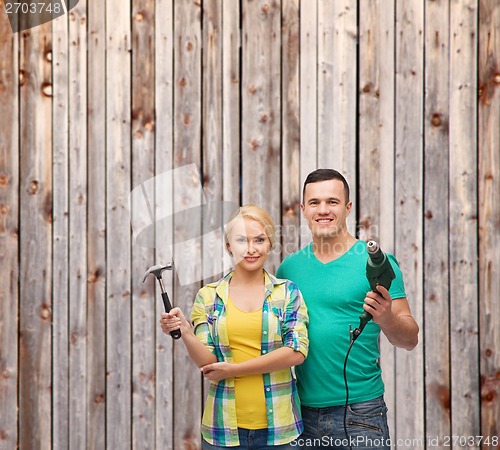 Image of smiling couple with hammer and drill