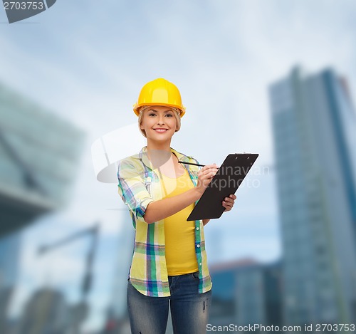 Image of smiling woman in helmet with clipboard