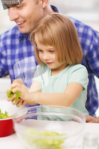 Image of smiling father and little girl at kitchen