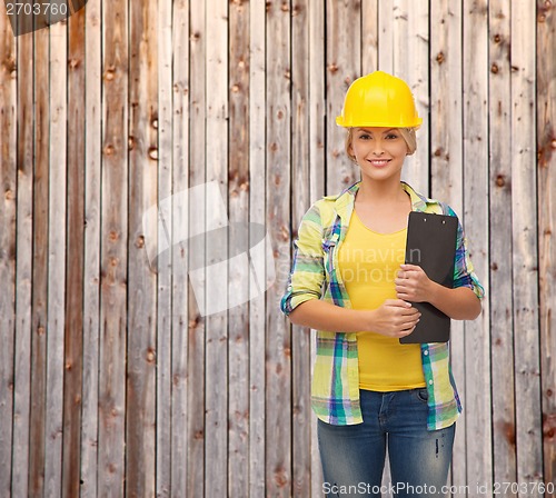 Image of smiling woman in helmet with clipboard