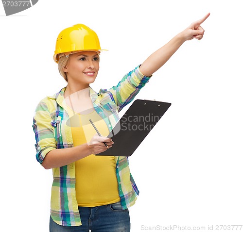 Image of smiling woman in helmet with clipboard