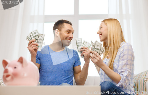 Image of couple with money and piggybank ot table at home