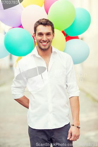 Image of man with colorful balloons in the city