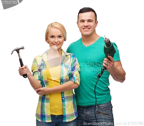 Image of smiling couple with hammer and drill