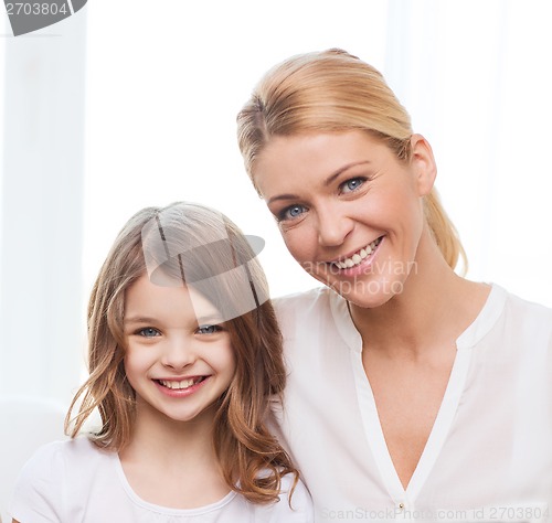 Image of smiling mother and little girl with laptop at home