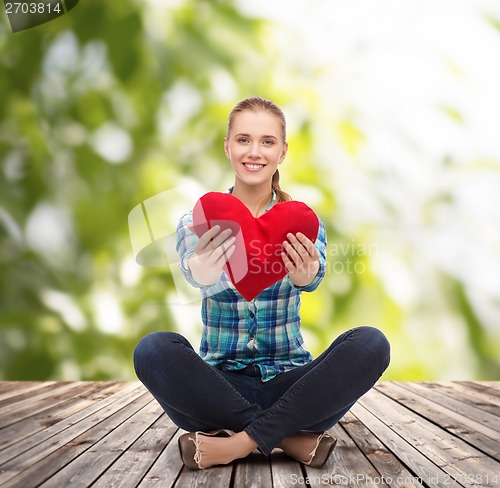 Image of young woman in casual clothes sitting on floor