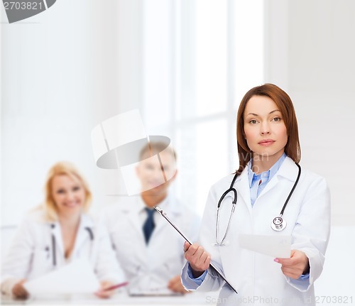 Image of calm female doctor with clipboard