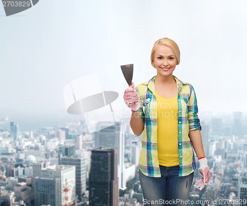 Image of smiling female worker in gloves with spatula