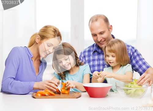 Image of happy family with two kids making dinner at home