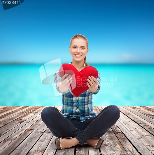 Image of young woman in casual clothes sitting on floor