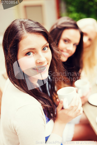 Image of beautiful girls drinking coffee in cafe