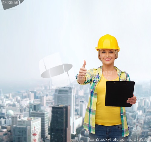 Image of smiling woman in helmet with clipboard