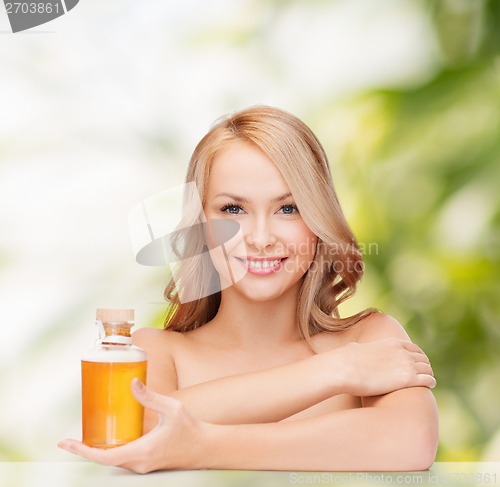 Image of happy woman with oil bottle