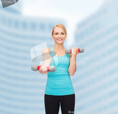 Image of young sporty woman with light dumbbells