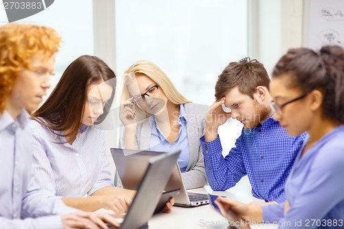 Image of depressed team with laptop and table pc computers