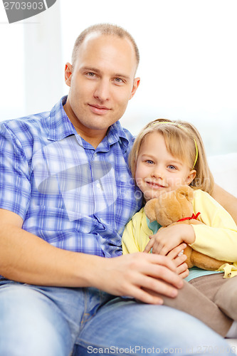 Image of smiling father and daughter with teddy bear