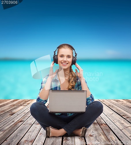 Image of young woman in casual clothes sitting on floor