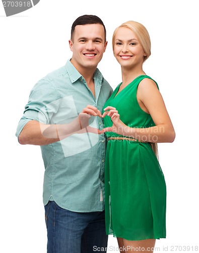 Image of smiling couple showing heart with hands