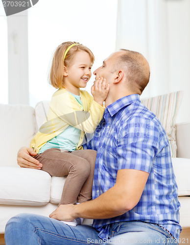 Image of smiling father and daughter playing at home