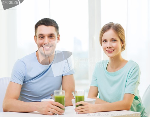Image of smiling couple having breakfast at home