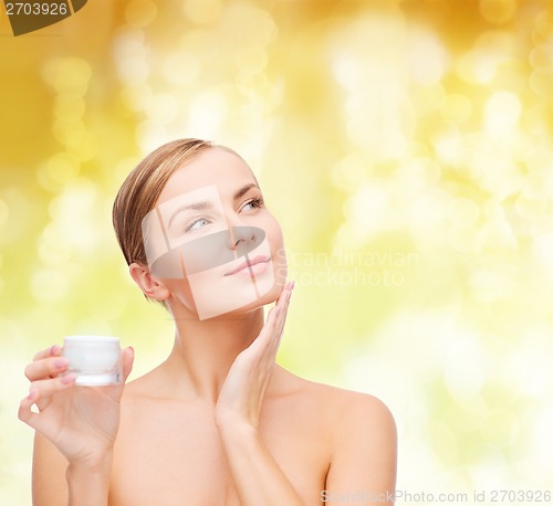 Image of woman applying cream on her skin