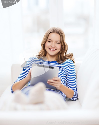 Image of smiling teenage girl with tablet pc at home