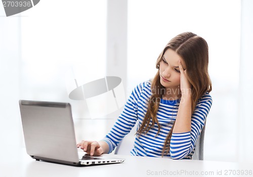 Image of upset teenage gitl with laptop computer at home