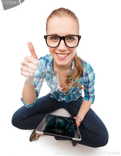 Image of smiling woman sitiing on floor with tablet pc