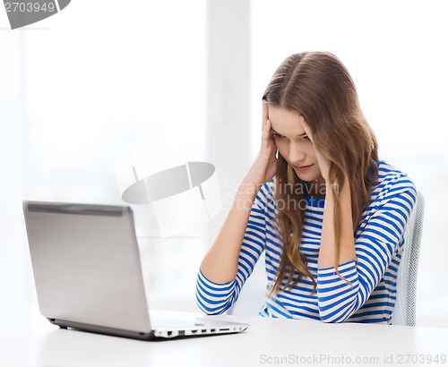 Image of upset teenage gitl with laptop computer at home