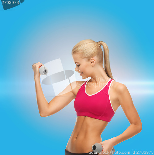 Image of young sporty woman with light dumbbells