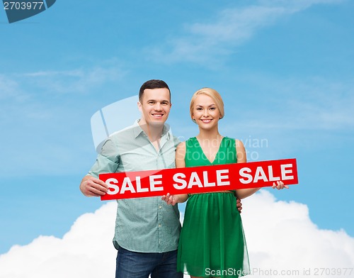 Image of smiling couple with sale sign